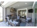 Outdoor kitchen featuring a built-in grill, stainless steel appliances, comfortable seating, and seamless access to pool at 2815 Dudley Ave, Odessa, FL 33556