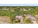 A birds eye view of a single Gathering home with mature trees and landscaping in a quiet neighborhood near a golf course at 3029 Harrow Rd, Spring Hill, FL 34606