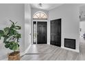 Inviting foyer with wood-look floors, a decorative plant, and a modern light fixture at 3047 Bolt Dr, Palm Harbor, FL 34685