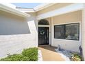 Close-up of the front entrance showcasing the arched window, wreath, and manicured bushes at 3047 Bolt Dr, Palm Harbor, FL 34685