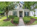 Charming two-story home featuring a balcony, black shutters, and a well-manicured front yard with lush landscaping at 3057 Riders Pass, Odessa, FL 33556