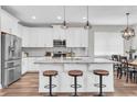 Modern kitchen with white cabinetry, stainless steel appliances, and a center island with bar stool seating at 3057 Riders Pass, Odessa, FL 33556