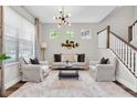 Bright living room featuring a modern light fixture, a comfortable seating arrangement, and stylish decor at 3057 Riders Pass, Odessa, FL 33556