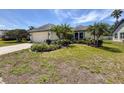 Well-maintained single-story home featuring a landscaped front yard with vibrant plants and a two-car garage at 3074 Cara Ct, Palm Harbor, FL 34684