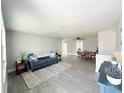Bright living room featuring modern flooring, a comfortable sofa, and an open layout with dining area at 3545 Oxford Dr, Holiday, FL 34691