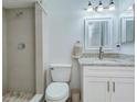 Bathroom features tiled walk-in shower and vanity with granite counters and white cabinets at 37733 14Th Ave, Zephyrhills, FL 33542