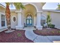Elegant home entrance featuring columns, arched entryway, and a seating area at 4044 Chesterfield Dr, Spring Hill, FL 34609
