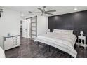 Cozy bedroom boasts a statement wall, ceiling fan, and a sliding barn door to the bathroom at 4315 Oakland Dr, New Port Richey, FL 34653