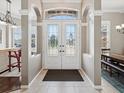 Elegant foyer with leaded glass doors, columns, and tile flooring at 4423 Gevalia Dr, Brooksville, FL 34604