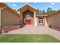 Inviting entrance showcasing brick accents, an arched entryway, and a red double-door entrance at 4469 Lake In The Woods Dr, Spring Hill, FL 34607