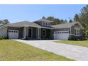 Beautiful home with a paver driveway leading to a two-car garage and a covered front porch at 6063 Dusk Rose Ln, Brooksville, FL 34601
