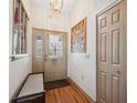 Inviting foyer with hardwood floors, a bench, and a decorative light fixture at 6080 Dexter Ln, Brooksville, FL 34602