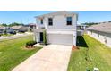 Two-story home with a two-car garage, manicured lawn and landscaping at 6561 Seaway Dr, Brooksville, FL 34604