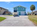 Turquoise home with a boat on the driveway and a waterfront view at 6622 Seaview Blvd, Hudson, FL 34667