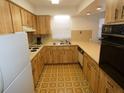 Galley kitchen featuring wood cabinets, laminate countertops, and retro flooring at 6636 Timbercove Ln # 6636, New Port Richey, FL 34653