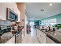 Modern kitchen with white cabinetry, granite countertops, stainless steel appliances, and open to the living space at 680 Argyll Dr, Spring Hill, FL 34609
