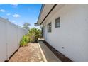 Exterior side view highlighting the white privacy fence and lush greenery at 6816 Sanderling Ln, Hudson, FL 34667