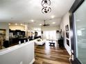 Open-concept living space with wood floors, a ceiling fan, and seamless flow to the kitchen and dining areas at 9089 Dupont Ave, Spring Hill, FL 34608