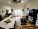 View of a contemporary living room with wood floors, a ceiling fan, and a dining area in the background at 9089 Dupont Ave, Spring Hill, FL 34608