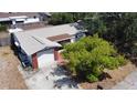 A charming home with a brick accent, single car garage and driveway surrounded by green trees and lush landscaping at 9104 Lido Ln, Port Richey, FL 34668