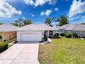 Inviting single-story home with a two-car garage, landscaped front yard, and a freshly paved driveway at 9237 Penelope Dr, Weeki Wachee, FL 34613