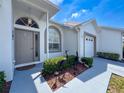 Close-up of the home's entry with a stylish front door, accent window, and manicured landscaping at 9336 Santa Monica Way, New Port Richey, FL 34655