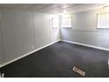 A carpeted bedroom with neutral paint and three windows at 9441 Teak St, New Port Richey, FL 34654