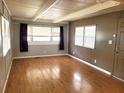 View of the living room features three windows and neutral paint at 9441 Teak St, New Port Richey, FL 34654