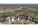 Aerial view of residential neighborhood showcasing homes, mature trees, and a tranquil pond at 9652 Oakwood Hills Ct, New Port Richey, FL 34655