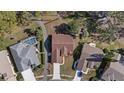 Birds-eye view of the home showing roof, pool, driveway and surrounding greenery in a tranquil neighborhood at 9652 Oakwood Hills Ct, New Port Richey, FL 34655