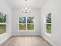 Dining room with modern chandelier, and large windows offering an abundance of natural light at 12331 Fulmar Rd, Weeki Wachee, FL 34614