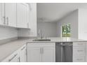 View of kitchen featuring modern stainless steel appliances, white cabinets, countertops and sink at 12331 Fulmar Rd, Weeki Wachee, FL 34614