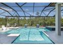 Inviting screened-in pool area with a spa, water features, and ample lounging space at 16557 Acoustic Loop, Land O Lakes, FL 34638
