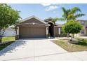 Attractive home featuring a spacious driveway, neutral exterior, and well-manicured landscaping for enhanced curb appeal at 18353 Briar Oaks Dr, Hudson, FL 34667