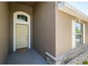 Inviting front entrance featuring an arched doorway, stone accents, and neutral tones for a modern aesthetic at 18353 Briar Oaks Dr, Hudson, FL 34667