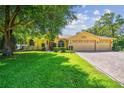 Inviting single-story home with a three-car garage, well-manicured lawn, and a paver driveway at 18502 Winding Oaks Blvd, Hudson, FL 34667