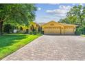 Desirable home with a well-maintained lawn, neat shrubs, and brick-paved driveway at 18502 Winding Oaks Blvd, Hudson, FL 34667