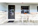 Cozy front porch with seating area and stone brick detailing on house facade at 1919 Harpoon Dr, Holiday, FL 34690