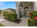 Close up of a home's entrance with beautiful green doors and colorful landscaped plants at 22118 Yachtclub Ter, Land O Lakes, FL 34639