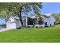 Charming white home with a well-manicured lawn and mature trees, enhancing its curb appeal at 2327 Morning Glory Trl, Spring Hill, FL 34606