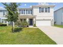 Two-story home with blue shutters, a well-manicured lawn, and a stone-accented facade at 3208 Living Coral Dr, Odessa, FL 33556