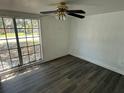 Bedroom showcasing dark ceiling fan, laminate flooring, and a large window for ample natural light at 3617 Rockaway Dr, Holiday, FL 34691