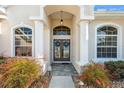 The front entrance features double doors flanked by fluted columns and sidelight windows beneath an arched transom at 4080 Gevalia Dr, Brooksville, FL 34604