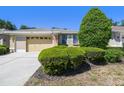 A well-kept single-story home with an attached two-car garage and neatly trimmed bushes in the front yard at 4500 Golf Club Ln, Spring Hill, FL 34609
