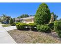 Cozy single-story home with a two-car garage and mature landscaping along the front walkway at 4500 Golf Club Ln, Spring Hill, FL 34609