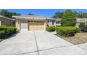 Inviting single-story home featuring a neatly manicured lawn, an attached two-car garage, and charming curb appeal at 4500 Golf Club Ln, Spring Hill, FL 34609