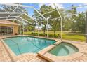 Sparkling screened-in pool and spa area with brick pavers and lush backyard views at 5164 Golf Club Ln, Spring Hill, FL 34609