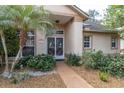 Inviting front entrance with decorative glass doors and lush tropical landscaping at 5638 Hereford Dr, New Port Richey, FL 34655