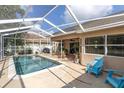 Relaxing screened-in pool area with clear water, stylish patio furniture, and ample space for outdoor enjoyment at 5638 Hereford Dr, New Port Richey, FL 34655