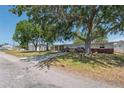 Street view of charming single-story home with brick facade, a spacious front yard with mature shade trees at 6521 Boatyard Dr, Hudson, FL 34667